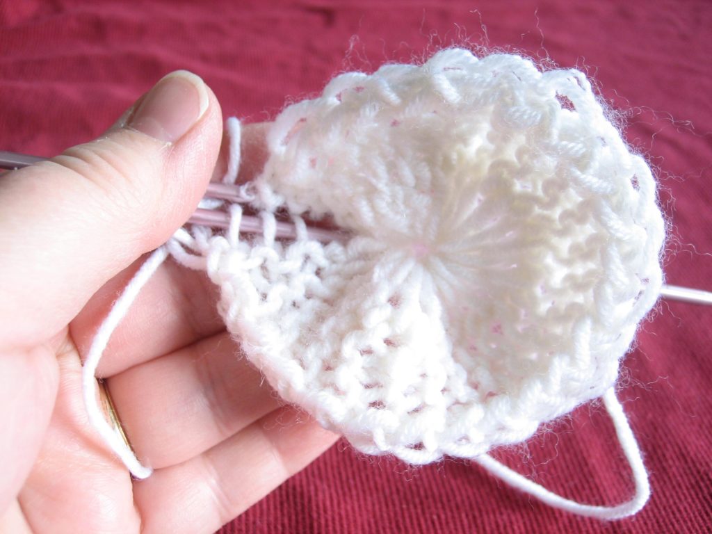 Pick up the initial stitches. Sew them to the current stitches, or use a 3 needle bind off, or graft them.