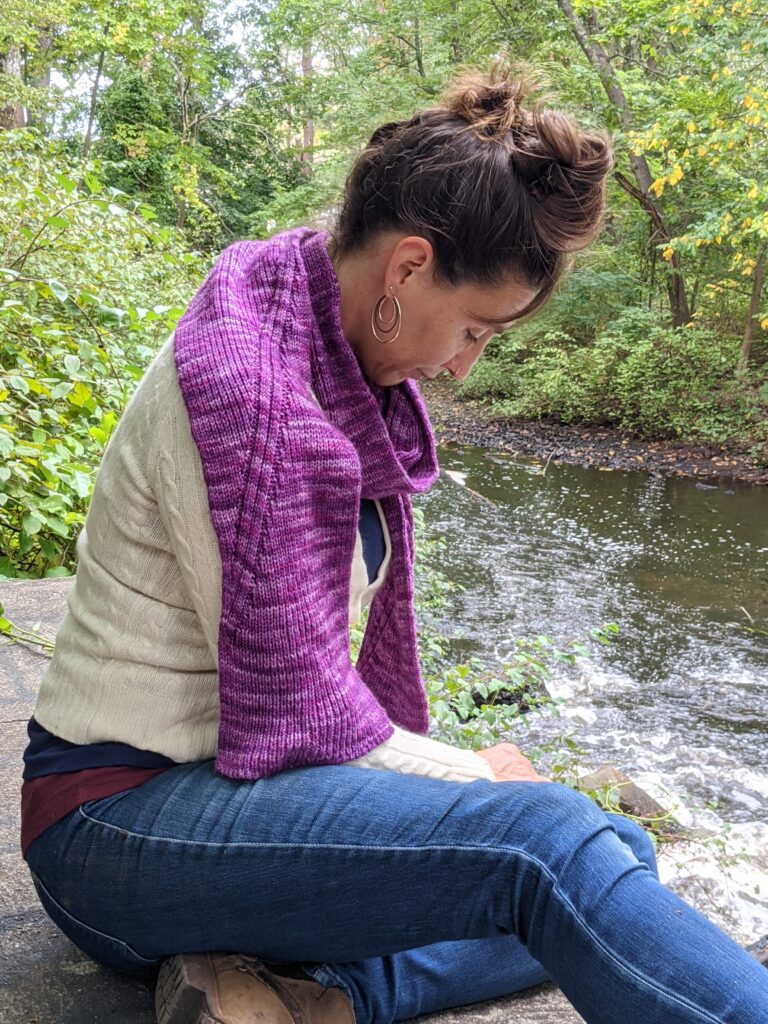 Woman wearing the Nicondo Scarf looks down on waterfall