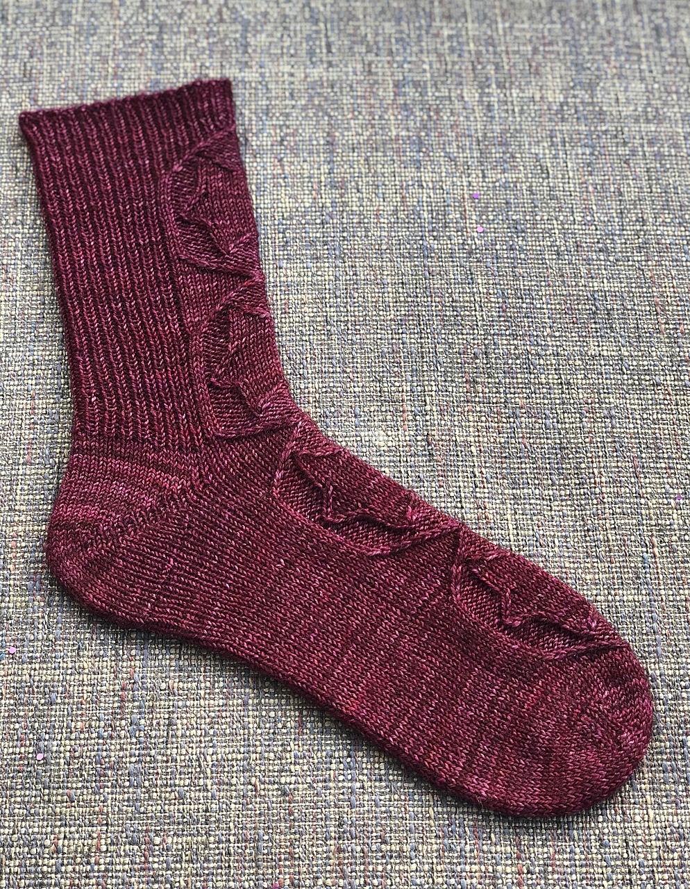 Plum Achird sock seen from the side, knit by Moniek