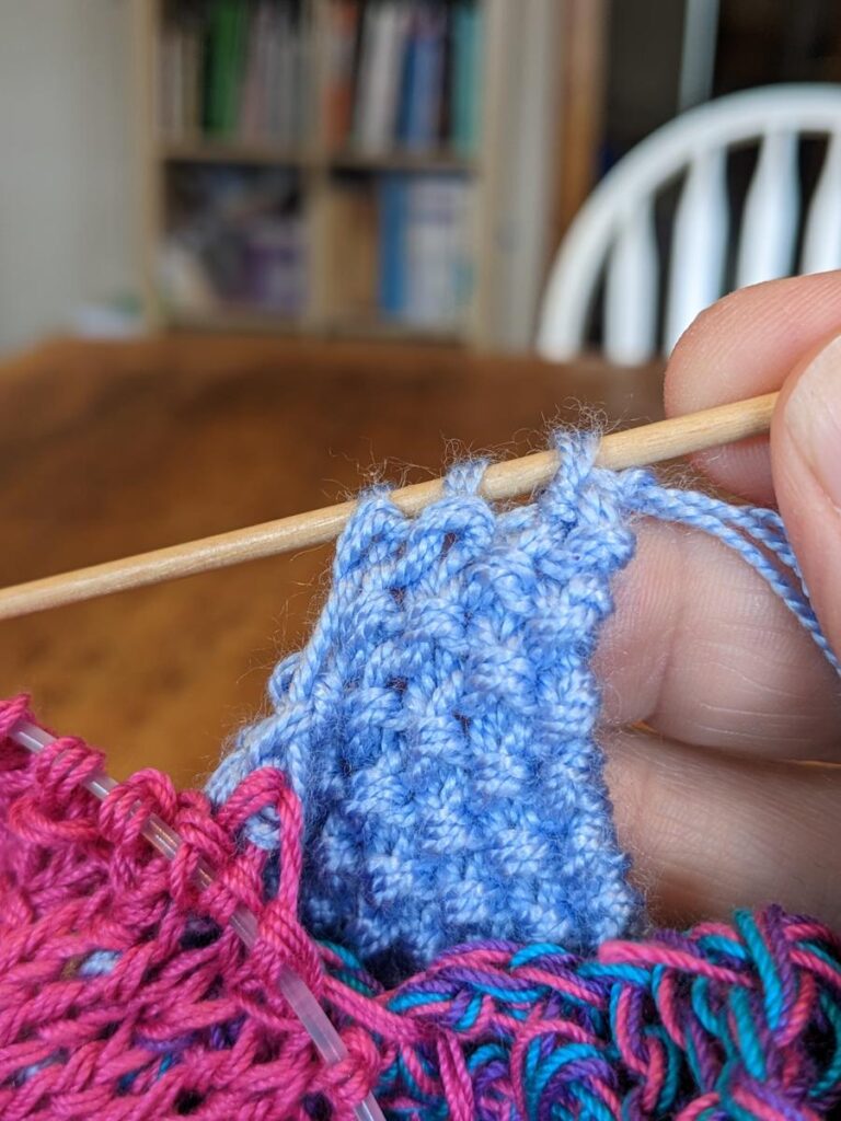 pale blue seed stitch page in a knitted baby book