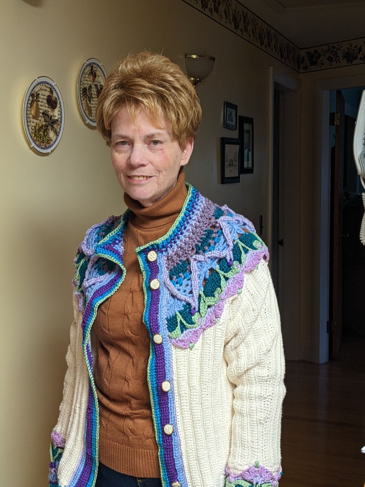 Aunt Susan wearing her Jerusalem Pottery Plate Sweater in my Mom's hallway by her plates