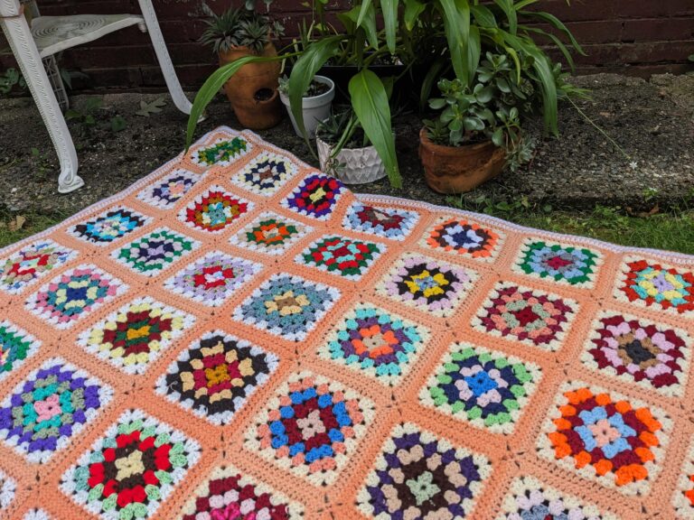 Afghan spread out near houseplants outside for the summer