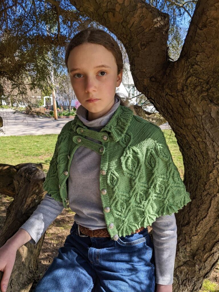 girl sits on tree limb wearing Silvia of ELF cape