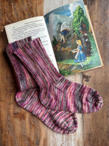 Stratum Socks shown over an illustrated book