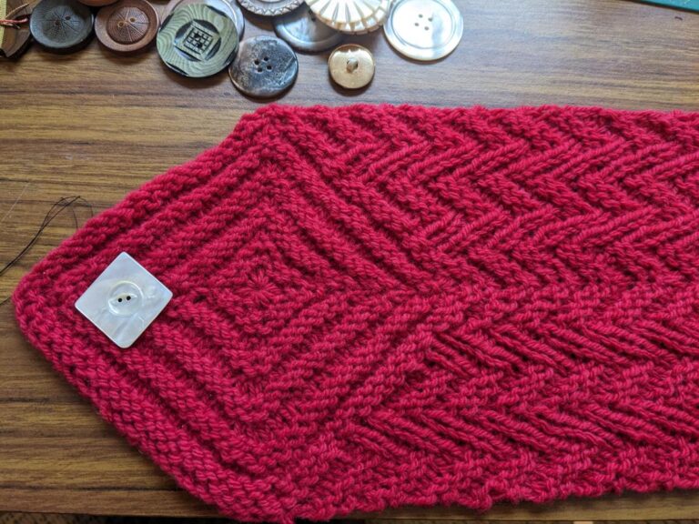 The Herringbone Hexagonal Cowl with many button options displayed on a desk